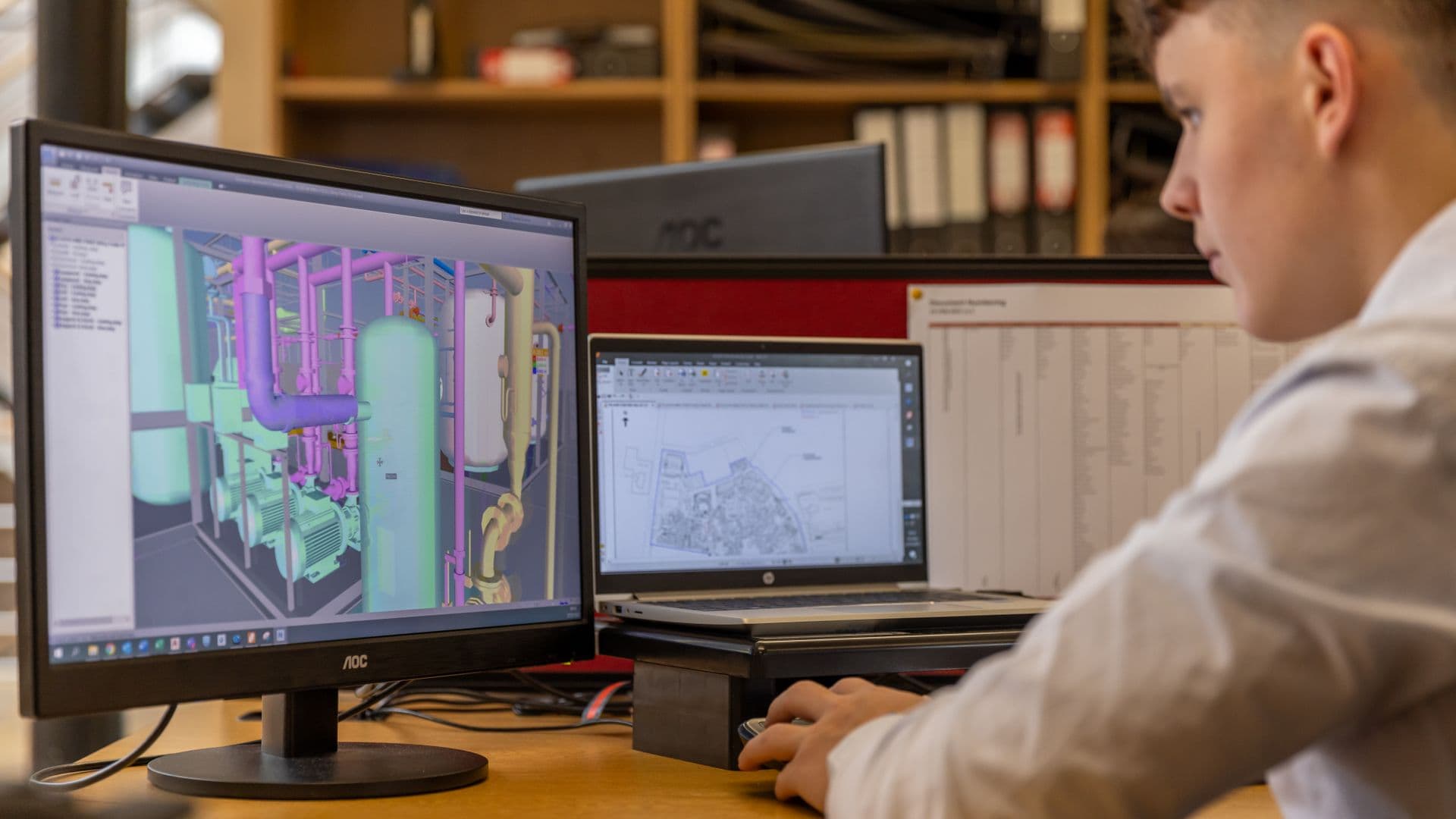 Projetista revisando o modelo 3D em dois monitores